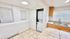 Bright kitchen with sleek countertops, natural wood cabinets, and a convenient in-unit washer and dryer. Perfect blend of style and functionality.