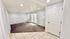 Bright and airy living space featuring modern recessed lighting, plush carpeting, and easy access to a tiled entryway.
