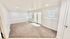 Bright and inviting living area with plush carpet, recessed lighting, and double French doors leading to the patio, ideal for relaxation and entertaining.