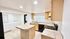 Bright and modern kitchen with tiled countertops, wooden cabinets, and built-in appliances.