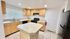 Modern kitchen with light wood cabinetry, island countertop, and sleek appliances illuminated by recessed lighting.