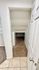 Cozy walk-in closet with built-in shelving and carpeted flooring, offering ample storage space.