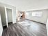 Bright open-plan apartment with modern kitchen, spacious living area, and sleek wood flooring.