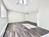 Bright and spacious living room featuring elegant wood flooring, modern ceiling fan, and abundant natural light.