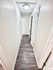 Bright and inviting hallway featuring sleek wooden flooring and modern doors, perfect for a contemporary apartment.
