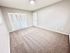 Bright, spacious bedroom with soft carpet and ample closet space, perfect for relaxation and storage.