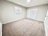 Bright and spacious room with plush carpeting, ample natural light, and sleek double closet doors.