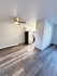 Modern apartment kitchen with sleek flooring, ceiling fan, and stylish stainless steel appliances.