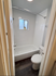 Bright and modern bathroom with sleek white tiles and a cozy bathtub.