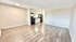 Bright and spacious open-concept living area featuring modern kitchen with sleek cabinetry and elegant wood flooring.
