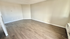 Bright and spacious empty room with elegant hardwood floors, perfect for versatile living arrangements.