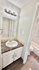Modern bathroom with elegant marble vanity, sleek lighting, and pristine finishes.