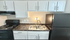 Modern kitchen with sleek black appliances, stylish marble countertops, and crisp white cabinetry.