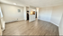 Bright and spacious open-plan living area with modern hardwood floors and a cozy kitchen with sleek cabinetry.