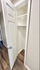 Inviting small closet with white door and wooden floors, perfect for extra storage in a stylish apartment.