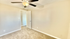 Inviting bedroom in a modern apartment featuring plush carpeting, neutral walls, and a sleek ceiling fan.