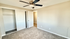 Bright and spacious bedroom with plush carpet, ceiling fan, and ample closet space.