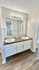 Modern bathroom with dual sinks and elegant countertop, featuring stylish lighting and spacious layout for convenience.