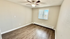 Inviting bedroom with elegant wood flooring, natural light, and a modern ceiling fan.