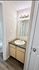 Inviting bathroom corner with a sleek marble countertop, modern sink, and elegant lighting.