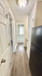 Charming hallway view featuring sleek hardwood floors and a glimpse into a bright bathroom.