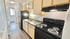 Modern kitchen with sleek black appliances, ample countertop space, and bright natural lighting.