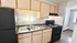 Modern kitchen with sleek black appliances, dual sink, and stylish wooden cabinetry, offering a contemporary cooking space.
