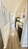 Inviting apartment hallway leading to a bright kitchen area with modern appliances and wooden cabinetry.