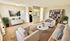 Spacious living room with modern decor, cozy seating area, and stylish bookshelf. Open access to the kitchen adds a touch of elegance.
