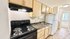 Charming kitchen with sleek black appliances, elegant granite countertops, and ample cabinetry for storage.