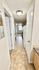 Bright hallway leading to a modern kitchen, featuring sleek appliances and ample natural light.
