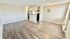 Bright, open living space with elegant hardwood flooring and a cozy atmosphere, leading into a modern kitchen.