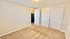 Bright, cozy bedroom with plush carpet and ample closet space, perfect for comfortable living.