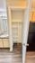 Modern apartment featuring a sleek bathroom vanity, spacious closet with built-in shelves, and stylish wood flooring.