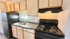 Charming modern kitchen featuring sleek black appliances, wood cabinetry, and stylish granite countertops.