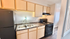 Modern kitchen featuring sleek black appliances, dual sink, and elegant wooden cabinetry.