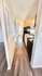 Modern apartment kitchen with sleek dark appliances, glossy countertops, and elegant wood flooring.