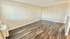 Spacious apartment room with elegant wood flooring and neutral wall tones, perfect for personalized decor.
