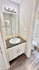 Chic bathroom design featuring a modern sink with marble countertop and stylish lighting, leading to a bright shower area.