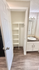 Bright bathroom with modern sink, elegant countertop, and spacious closet with shelves.