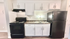 Contemporary kitchen with sleek black appliances and modern cabinetry design.