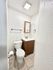Bright, modern bathroom featuring a sleek vanity with ample storage, elegant tiled flooring, and a pristine white toilet.