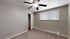 Bright and spacious bedroom with modern ceiling fan and large window for natural light.