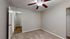 Bright and cozy bedroom with neutral tones, featuring plush carpet and a modern ceiling fan, adding comfort and style to any home.
