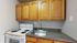 Cozy kitchen corner featuring sleek countertops, an electric stove, and ample wooden cabinet storage.
