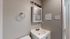 Modern bathroom with sleek fixtures, featuring a white vanity, wall-mounted mirror cabinet, and neutral-toned walls.