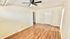Bright, open-concept living room with sleek wood flooring, ceiling fan, and ample natural light.