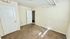 Bright, unfurnished room with natural light, textured carpeting, and neutral walls, ideal for personalization.