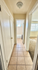 Inviting apartment hallway with natural light leading to a cozy bathroom and bright living area.