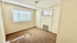 Bright and airy room with large windows, neutral walls, and cozy carpeting, perfect for a comfortable living space.